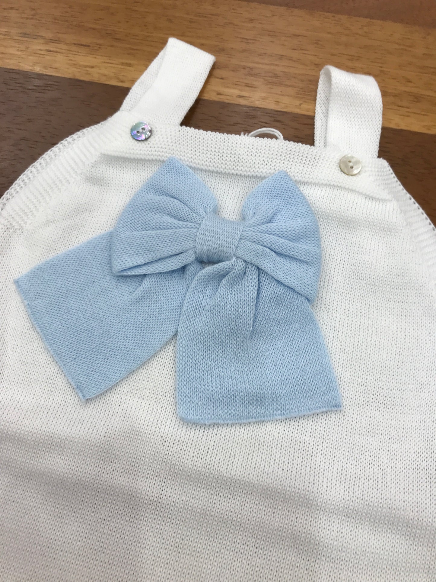 Salopette Baby Lord in filo bianco con bretelle con fiocco celeste applicato sul davanti