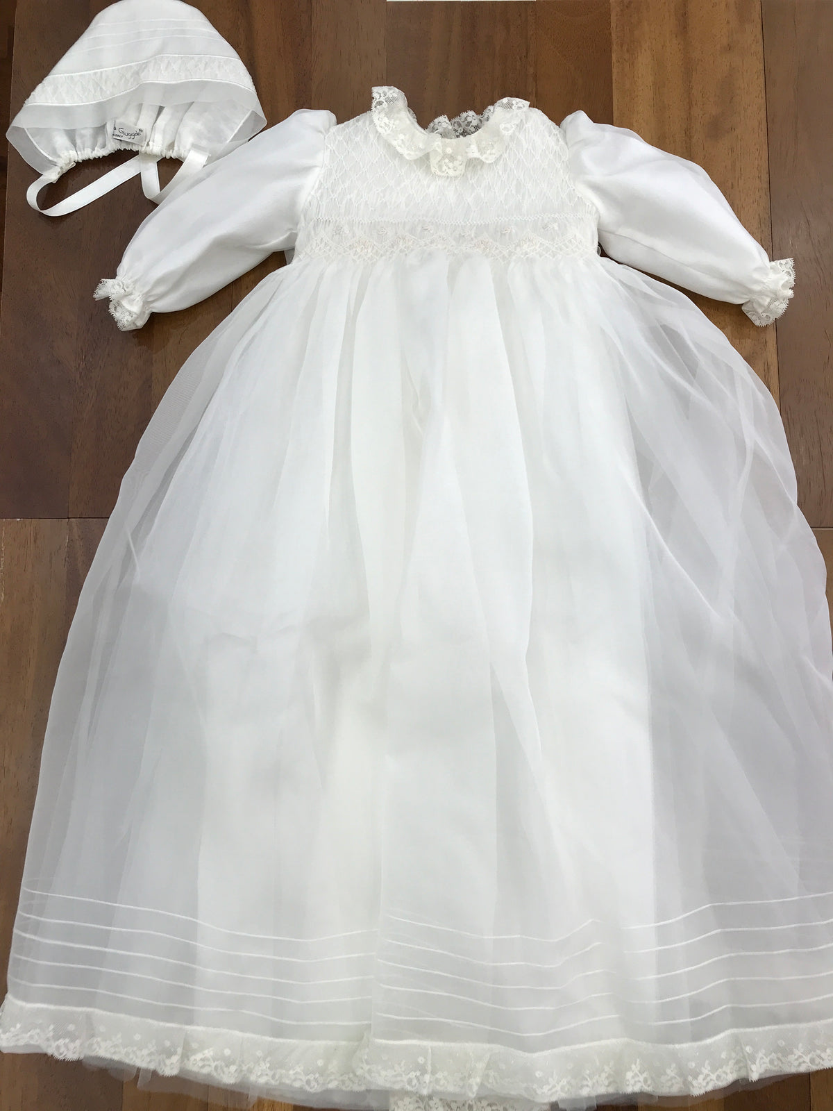 Abito lungo Piccola Giuggiola in organza in seta con gonna lavorata da pizzo corpetto manica lunga con lavorazione di punto smock e roselline ricamate a mano con cuffia coordinata e con punto smock