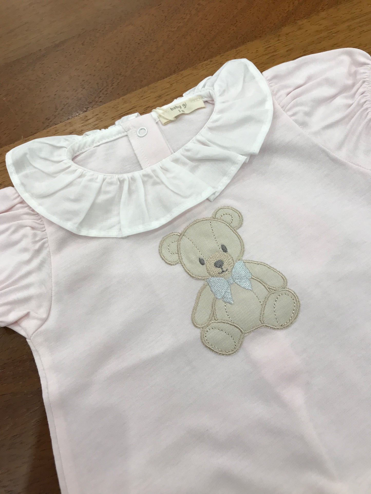 Pagliaccetto Baby Gi in cotone rosa corto mezza manica a sbuffo con con collo con rusche bianca con orsetto centrale