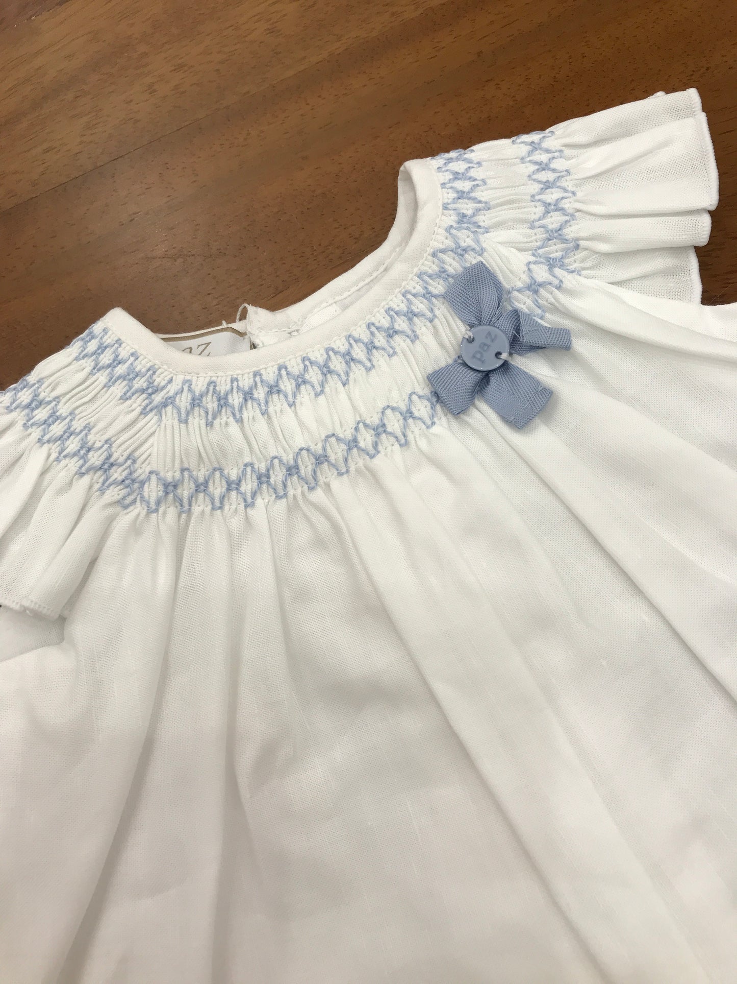 Pagliaccetto Paz Rodriguez in lino bianco con collo lavorato da punto smock in celeste con culotte abbinata in filo traforata