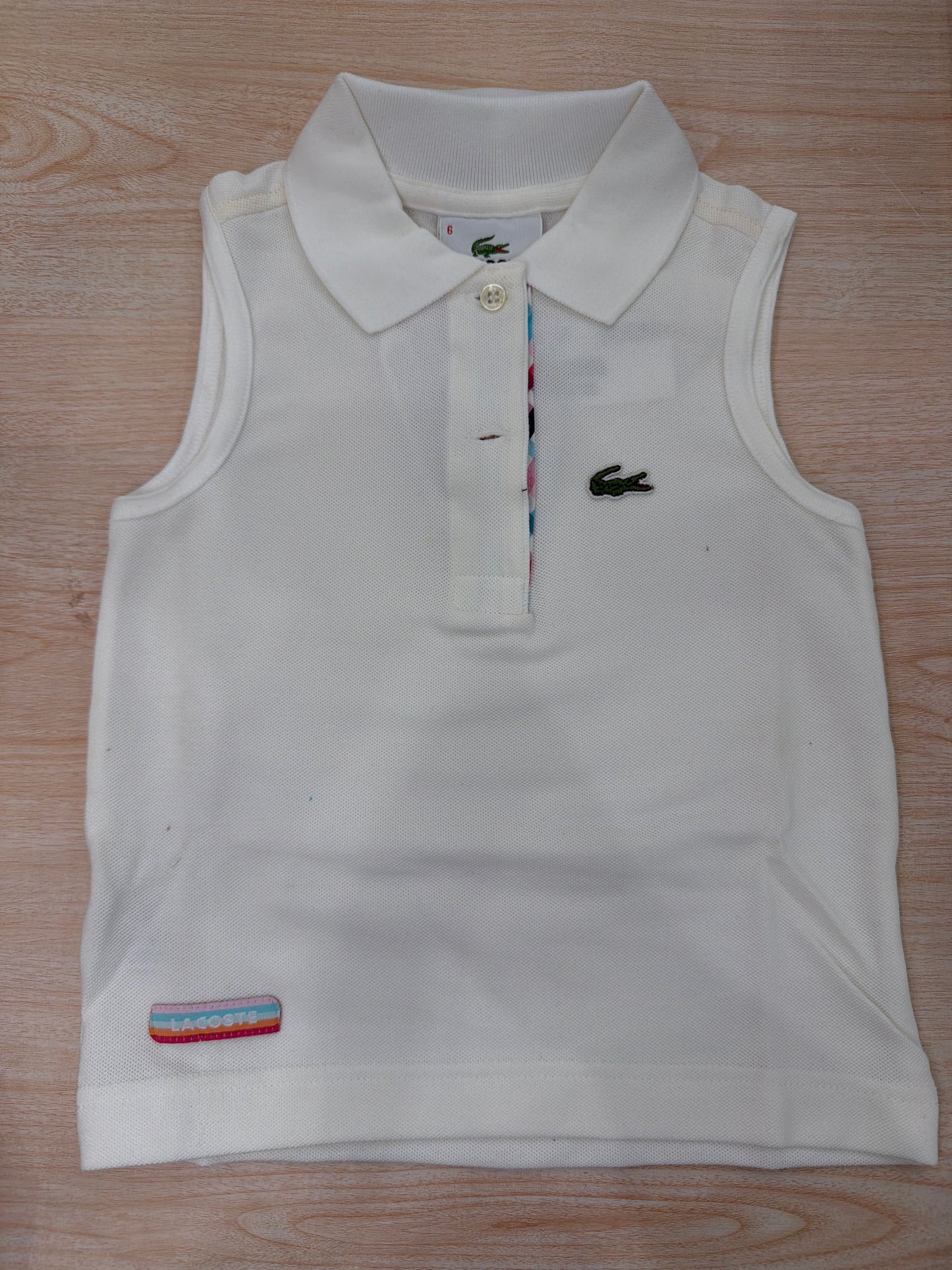 Polo Lacoste in cotone smanicata con bottoncini e logo ricamato lateralmente