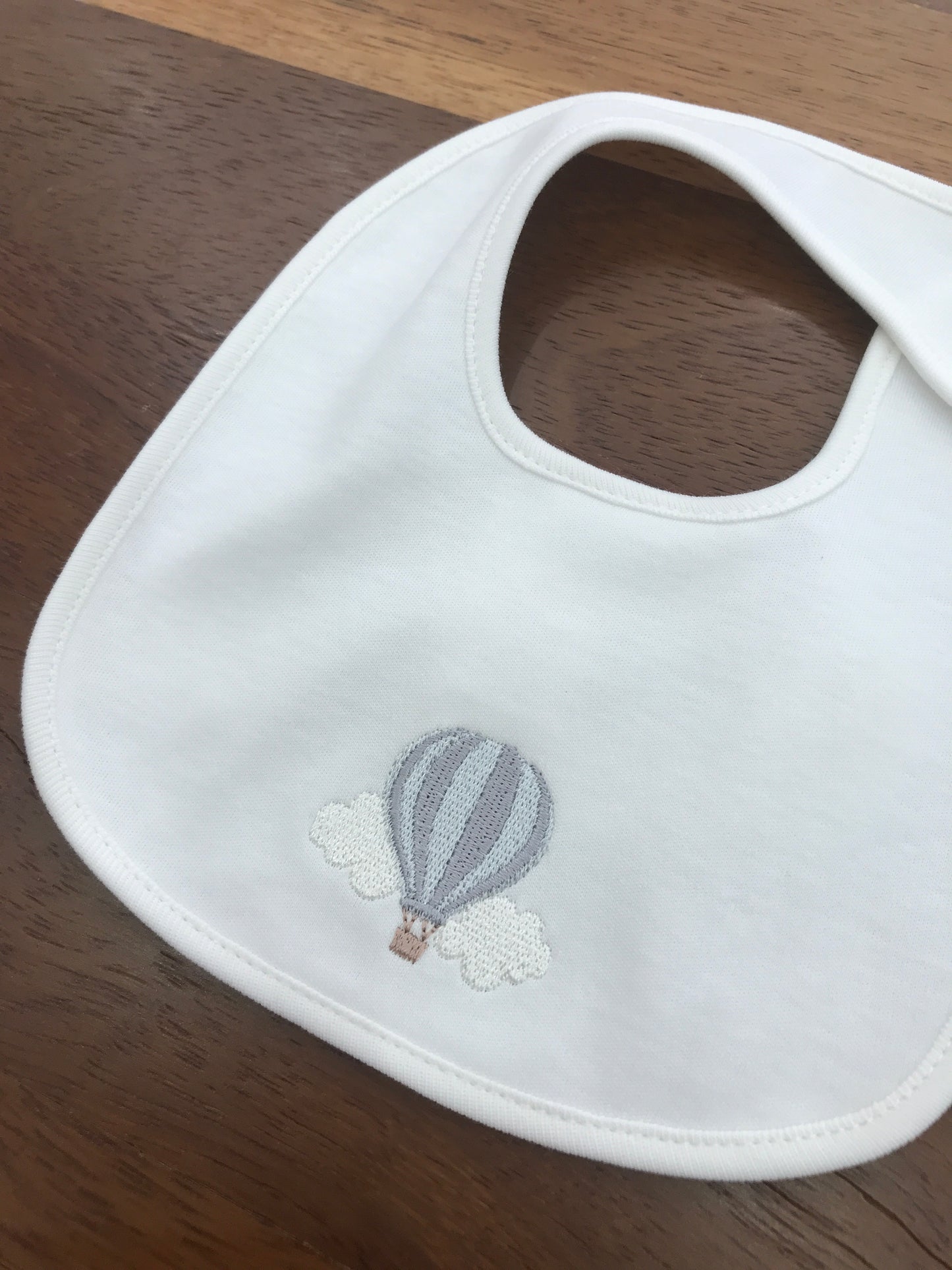 Bavetta Baby Gi in cotone bianca con mongolfiera ricamata sul davanti