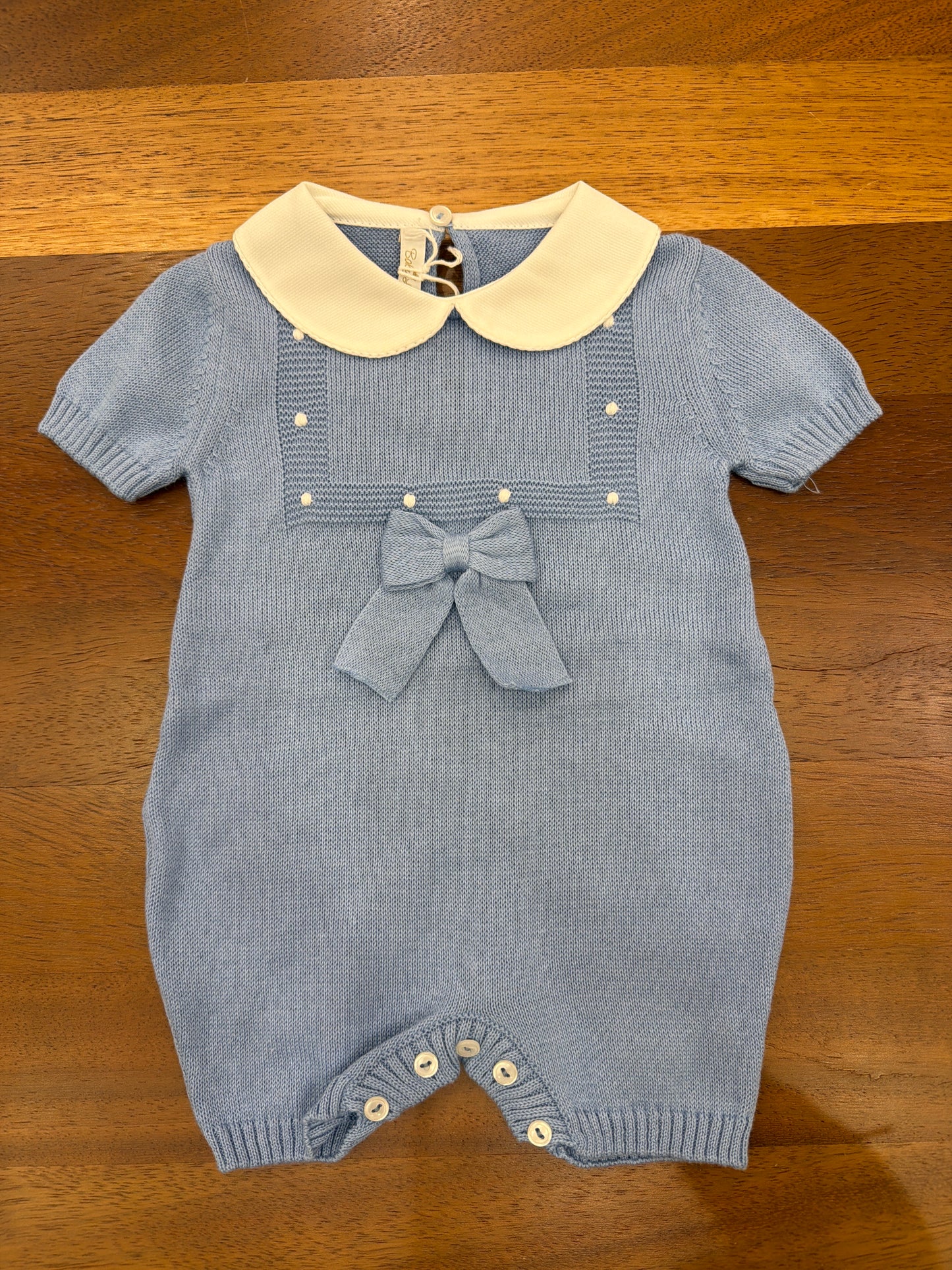Pagliaccetto Baby Lord in filo celeste mezza manica collo tondo bianco riquadro con lavoro a maglia con pois bianchi e fiocco