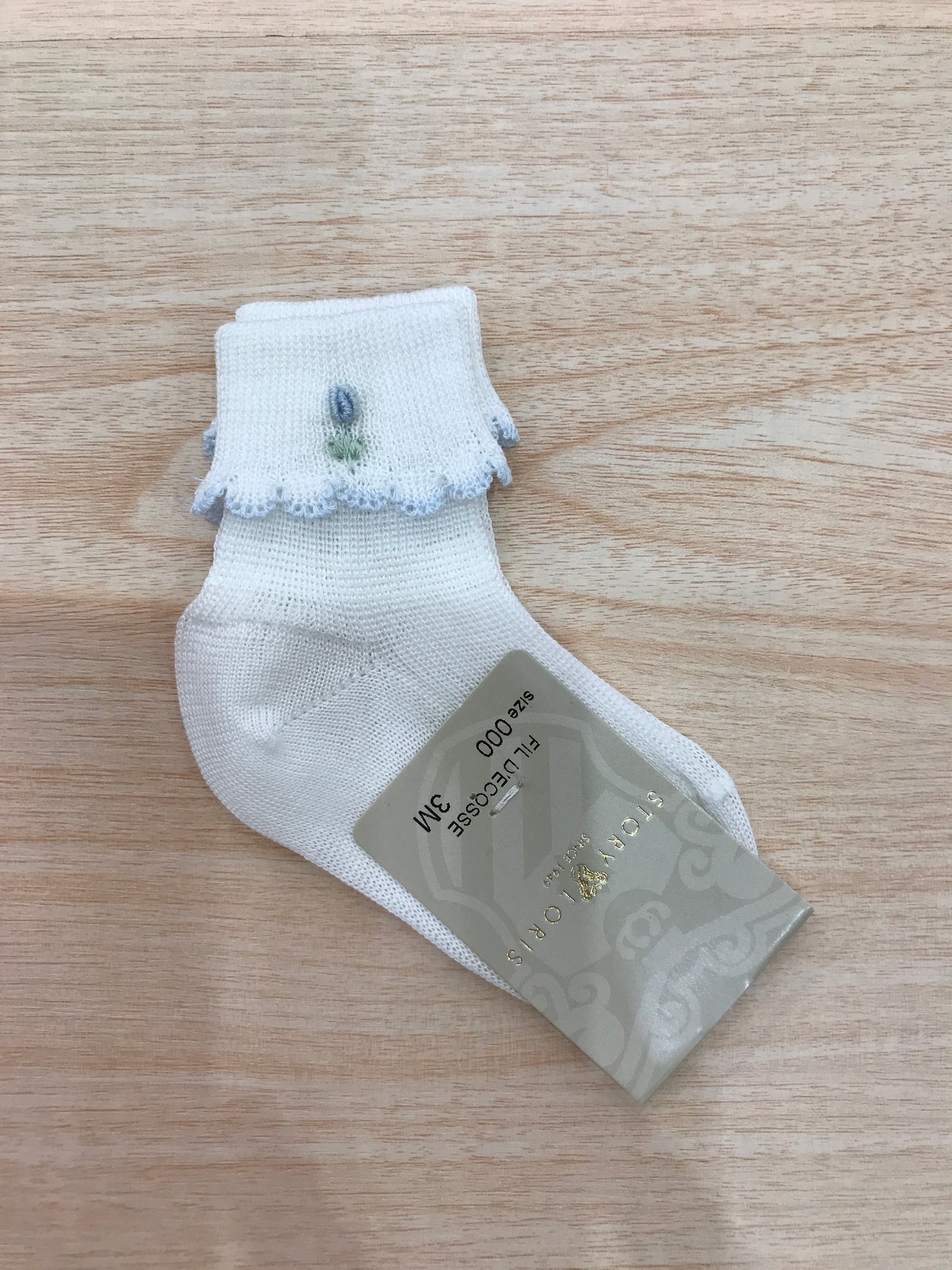 Calzino Story Loris in filo bianco con smerlo celeste con fiore celeste ricamato
