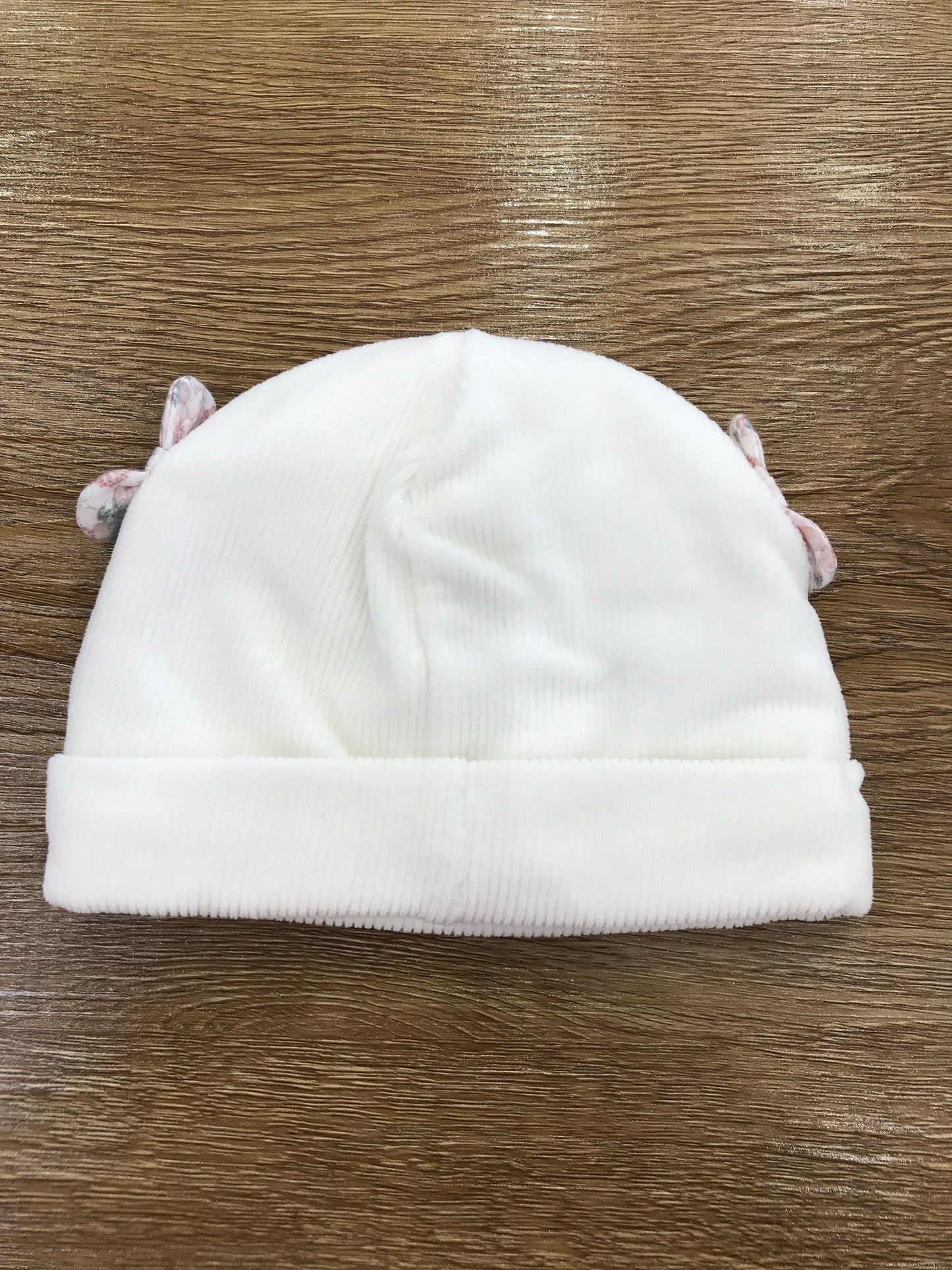 Cappello Nanan in ciniglia con risvolto e fiocchetti laterali con fiori