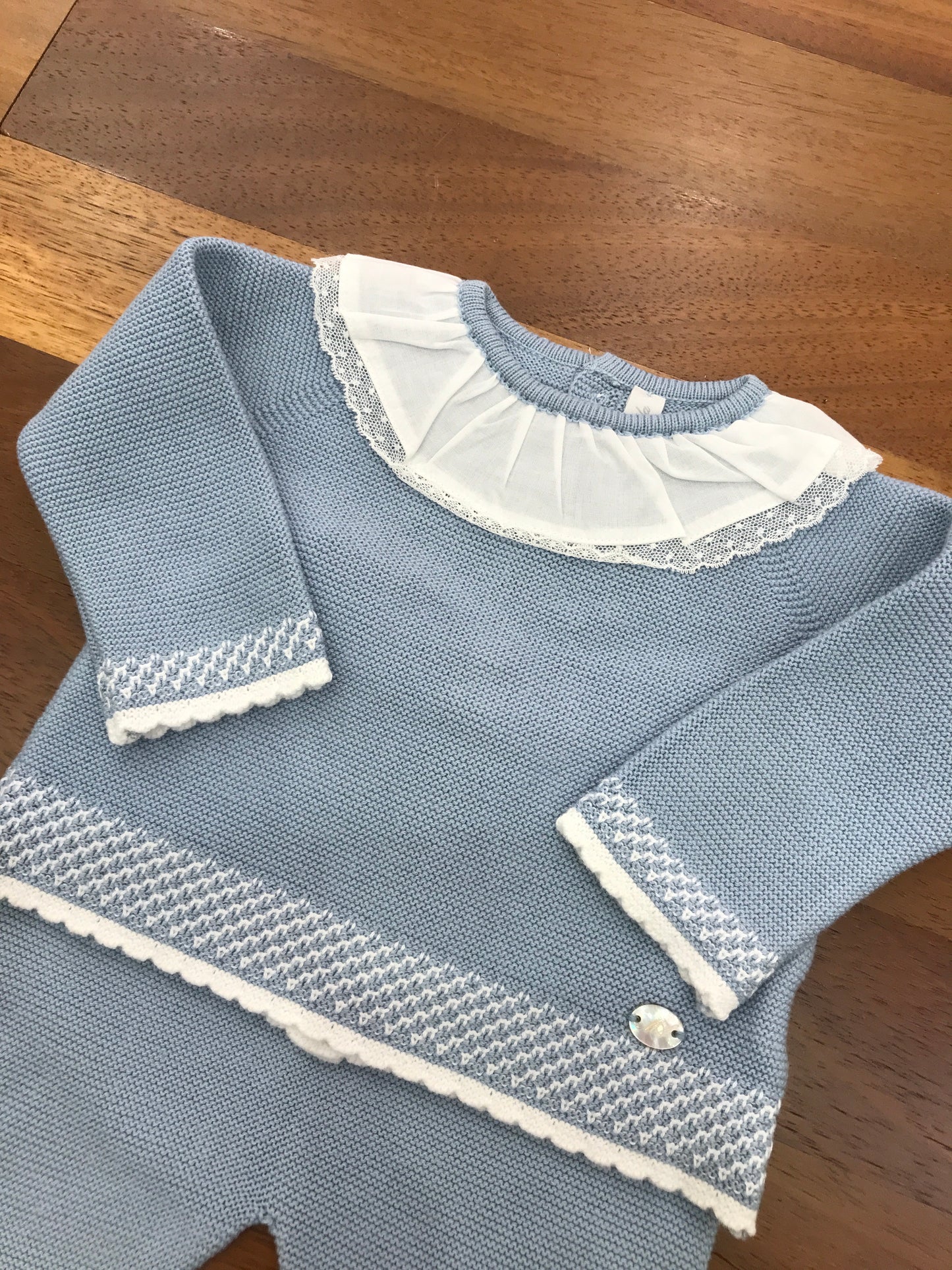 Tutina Martin Aranda in filo celeste polvere due pezzi con piedini manica lunga dettagli in bianco collo con rusche bianca