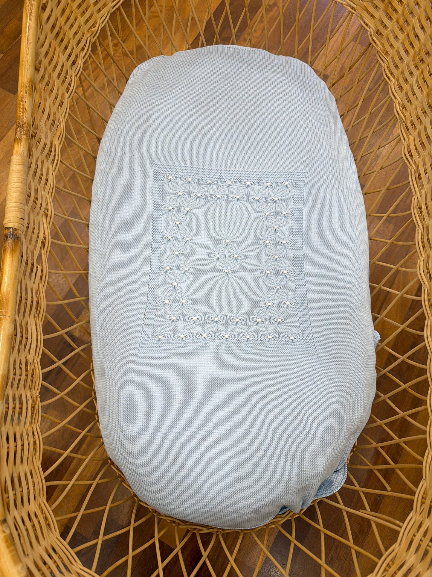 Coperta Baby Lord in filo celeste con lavorazione di punto smock bianco sul davanti