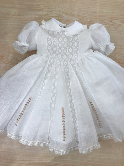 Abito Piccola Giuggiola in lino bianco corpetto lavorato con inserti di valancienne roselline rosa ricamate sulla gonna a ruota mezza manica e colletto rifinito anch'essi da valancienne