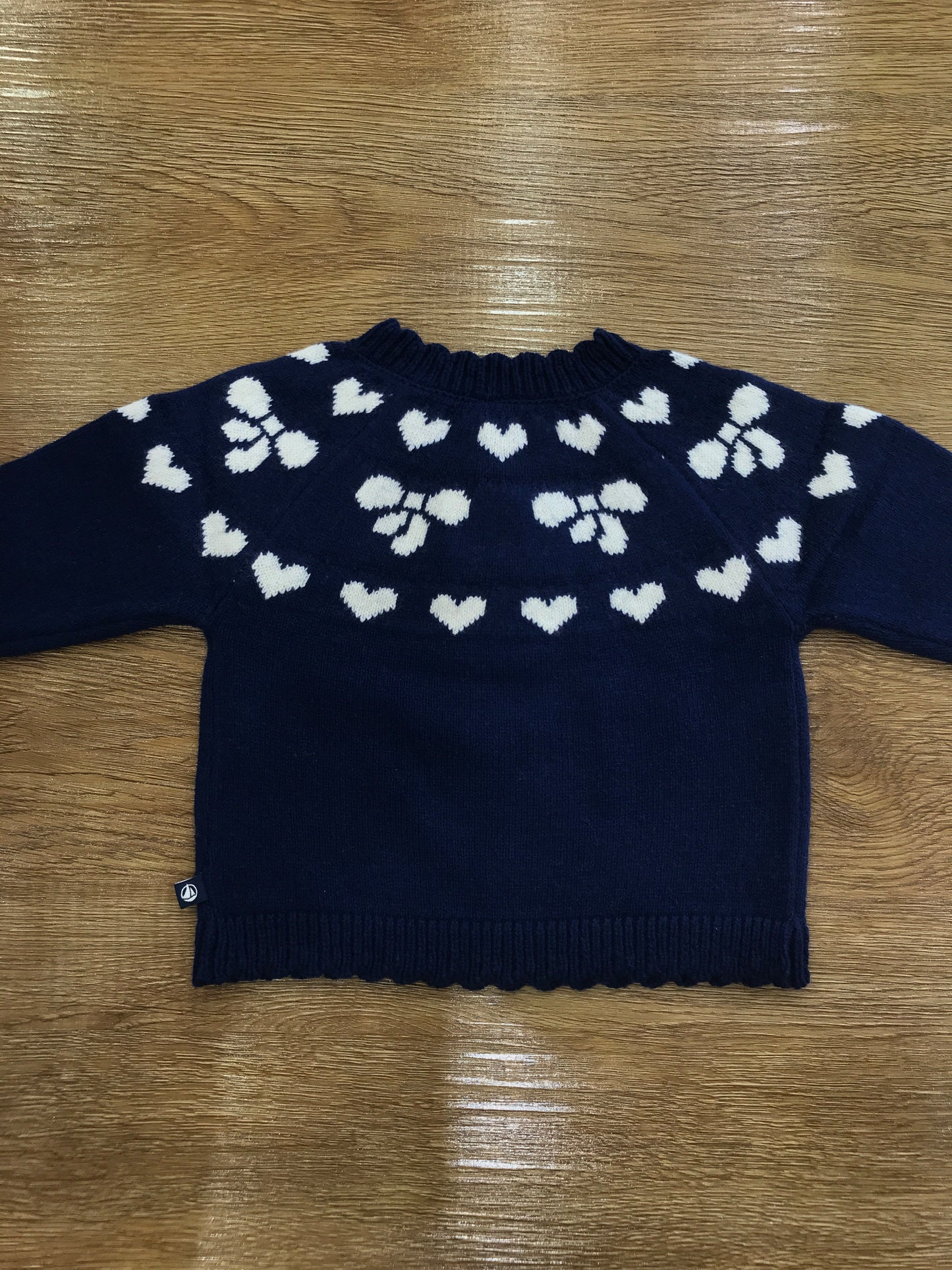 Maglioncino Petit Bateau blu scuro con cuoricini e fiocchetti bianchi ricamati con piccoli bottoncini laterali