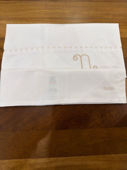 Lenzuolino Nanan in cotone bianco con logo nanan beige sulla federa con passanastro su lenzuolino