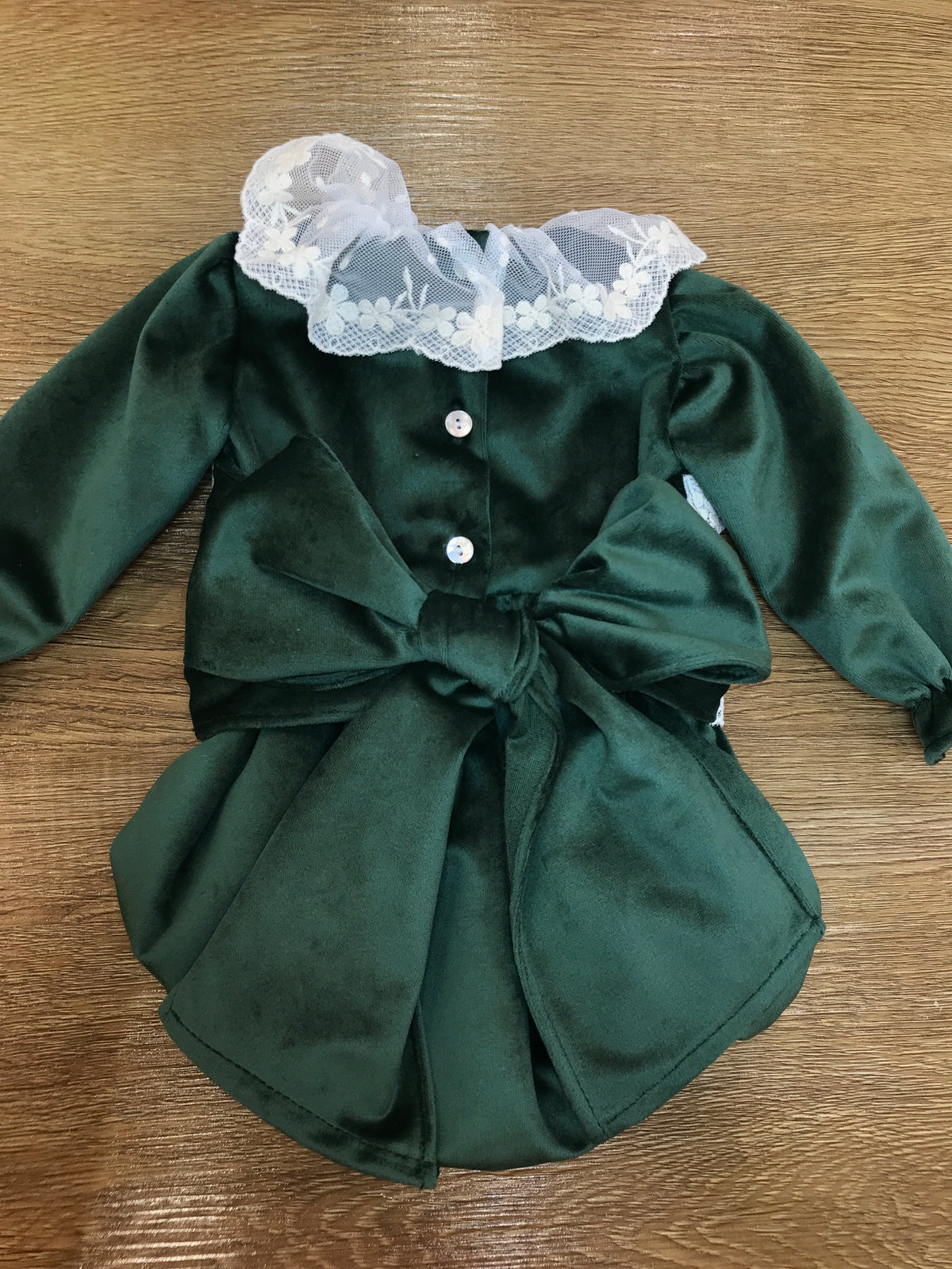 Pagliaccetto Fofettes verde in velluto con rusche in pizzo applicata anche al centro fascia con fiocco sul retro