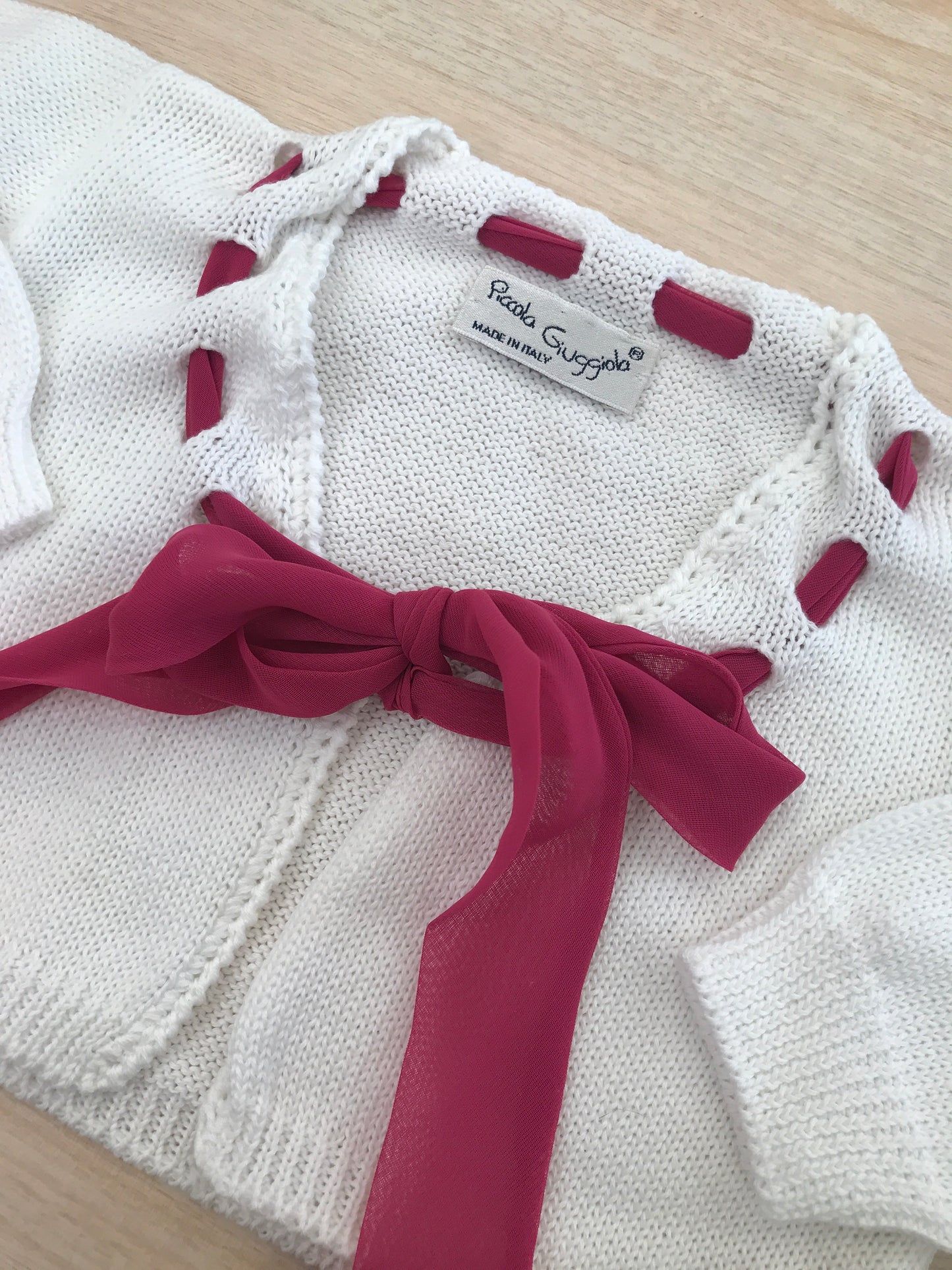Cardigan Piccola Giuggiola in filo bianco con laccio fucsia