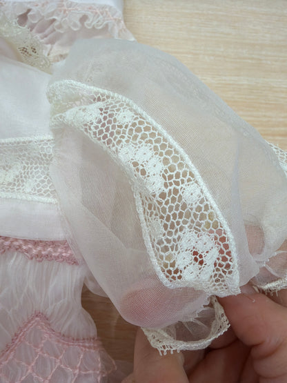 Abito Piccola Giuggiola in organza in seta rosa con applicazione di pizzo sul gonnellone e corpetto con lavorazione di punto smock e fiori ricamati con cuffietta abbinata