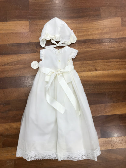 Abito Belan in organza in seta e battista di cotone smanicato con lavorazione di pizzo applicato sul davanti e sulla gonna con pieghe coordinato con cuffietta