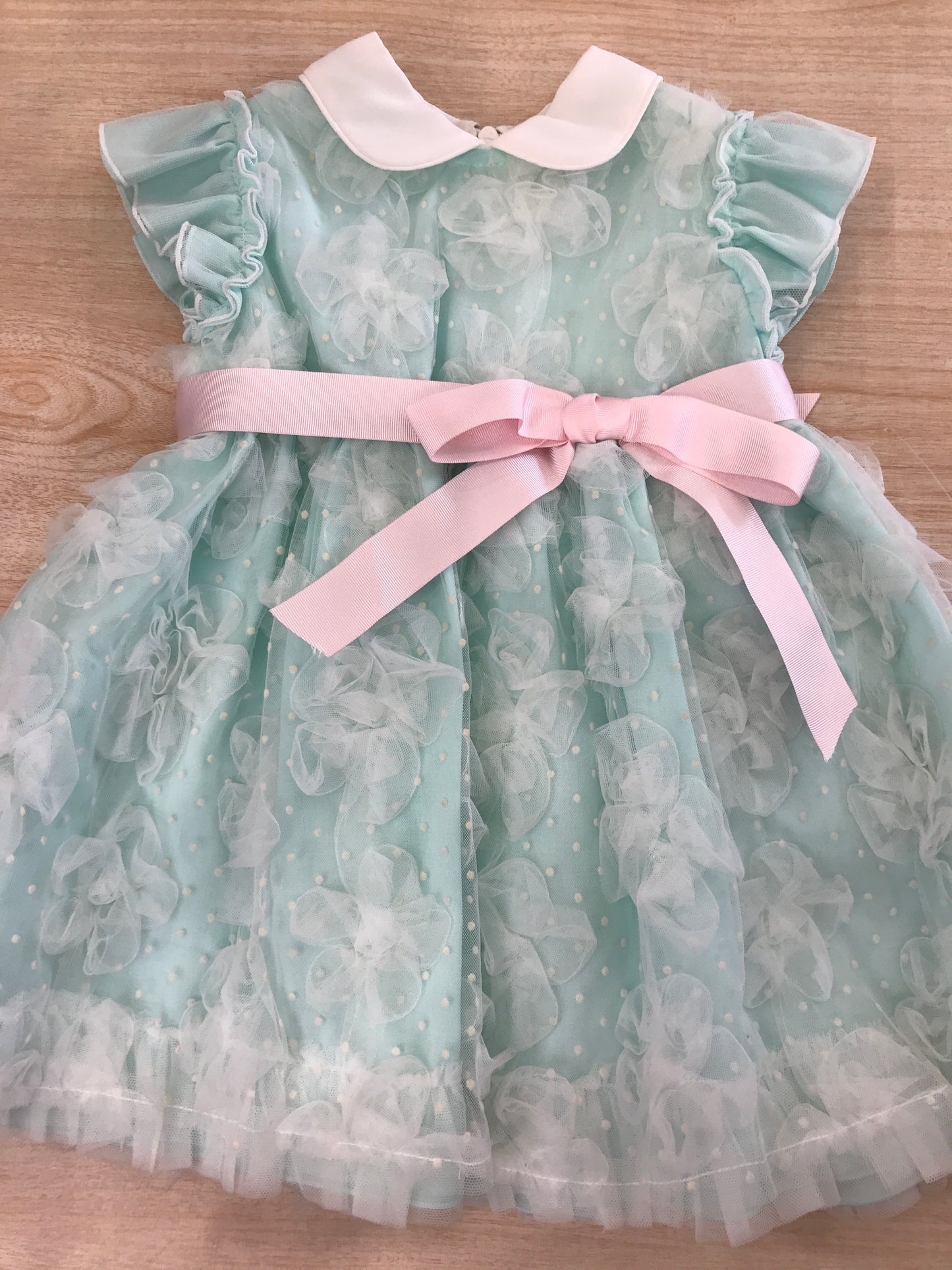 Abito Cielo Blu in cotone rivestito da tulle con tanti piccoli fiocchi e pois smanicato con rusche con fiocco rosa sul davanti e retro