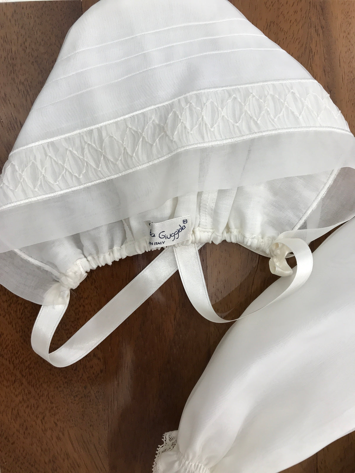 Abito lungo Piccola Giuggiola in organza in seta con gonna lavorata da pizzo corpetto manica lunga con lavorazione di punto smock e roselline ricamate a mano con cuffia coordinata e con punto smock