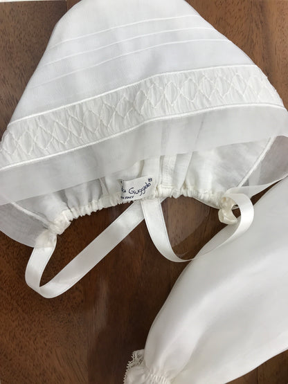Abito lungo Piccola Giuggiola in organza in seta con gonna lavorata da pizzo corpetto manica lunga con lavorazione di punto smock e roselline ricamate a mano con cuffia coordinata e con punto smock