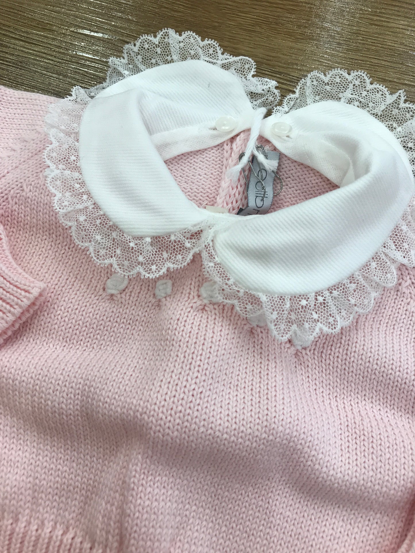 Tutina Colibrì in filo rosa due pezzi manica lunga gamba lunga con lavorazione di rose bianche sul davanti con collo con rusche rifinita da pizzo