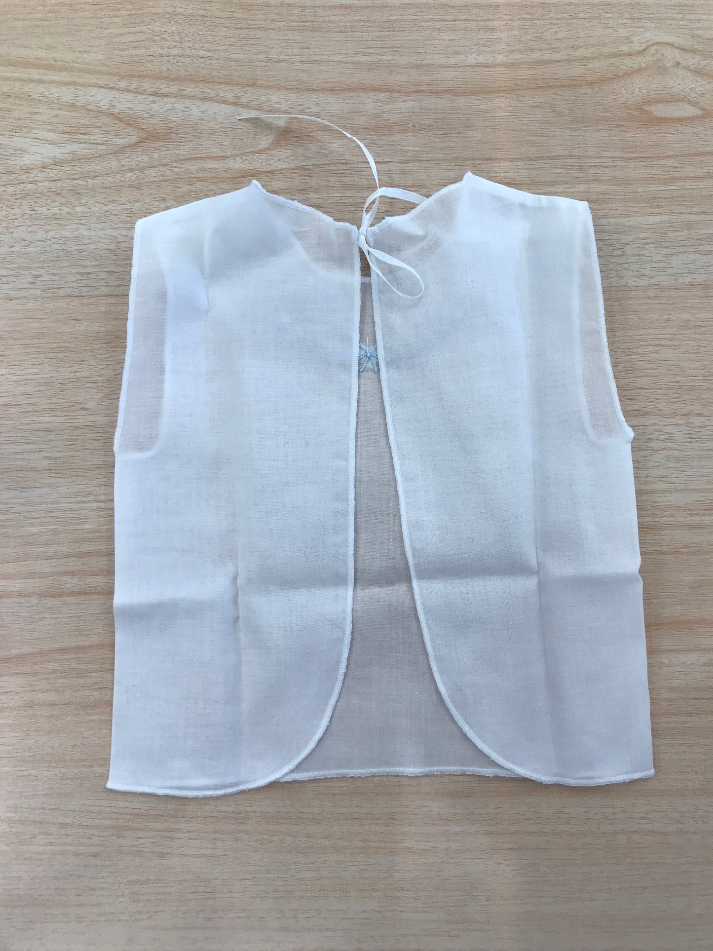 Camicino Baby gi in cotone bianco smanicato con pois e fiocchetto celeste ricamato al centro sul davanti
