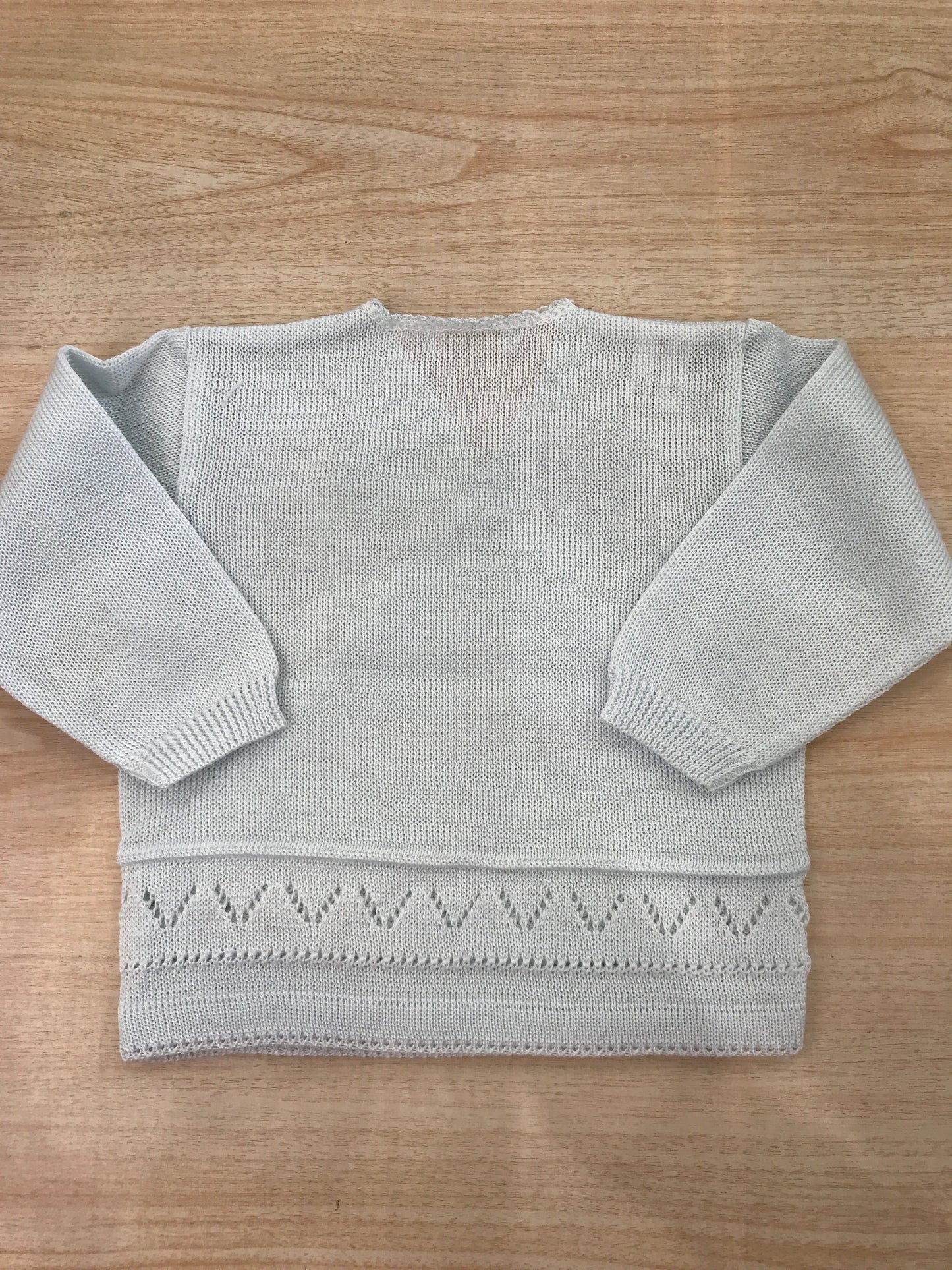 Cardigan Baby Lord in filo celeste chiaro ad incrocio con lavorazioni in basso