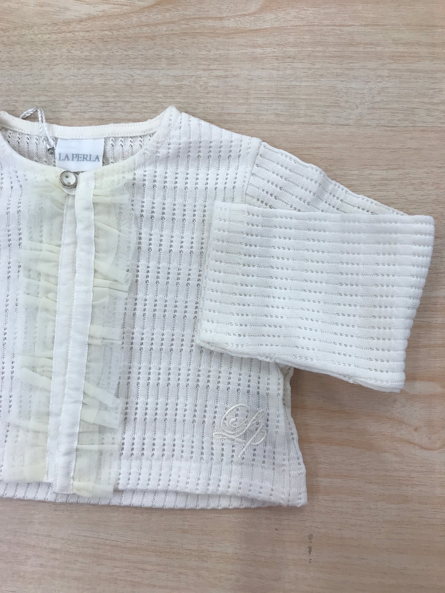 Cardigan La Perla in filo di cotone panna con un bottoncino sul davanti e rusche