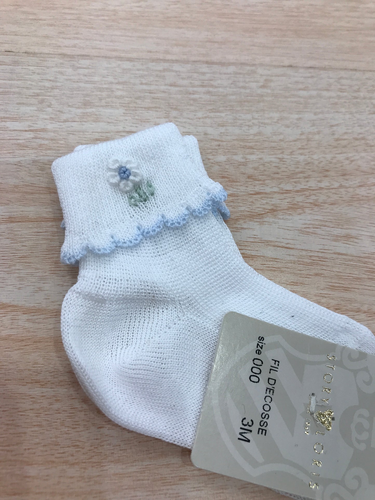 Calzino Story Loris in filo bianco con smerlo celeste con margherita ricamata a mano