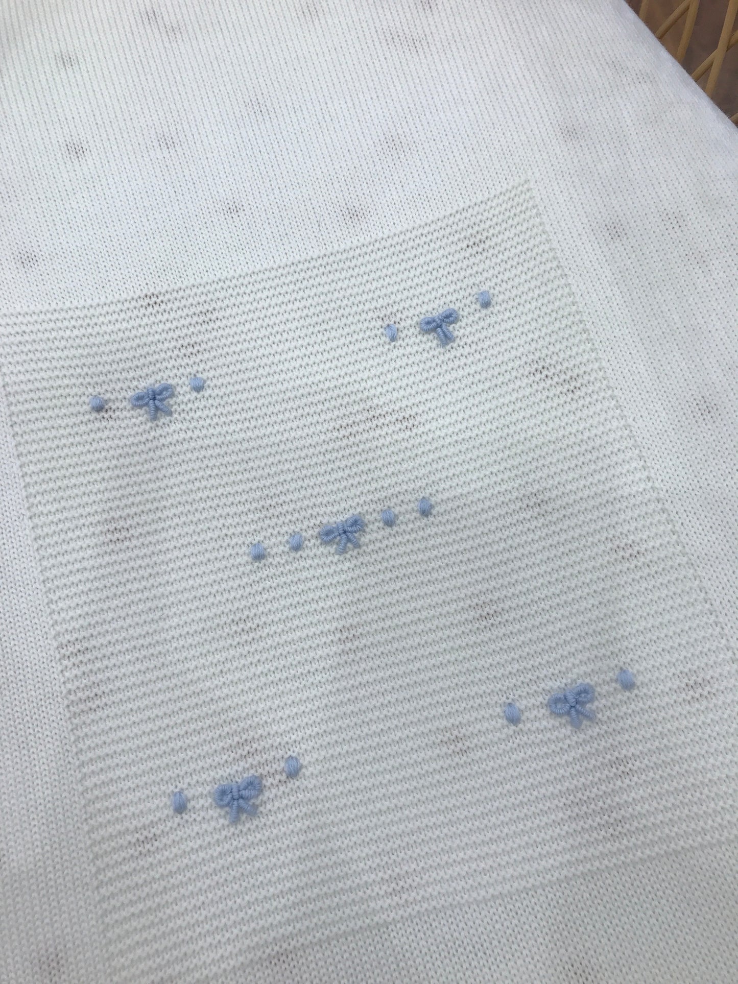 Coperta Baby Lord in lana panna con nodi d'amore celesti ricamati al centro