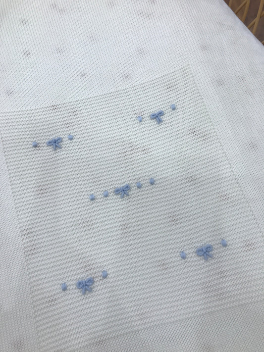 Coperta Baby Lord in lana panna con nodi d'amore celesti ricamati al centro