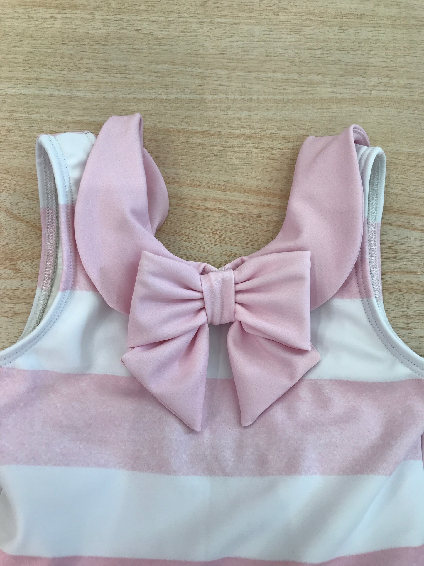 Costume Fofettes intero a righe bianche e rosa con rusche rosa a spallina con fiocco sul davanti