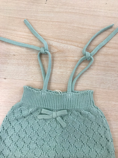Salopette PCS in filo verde lavorata a maglia con fiocchetto sul davanti e bretelle regolabili