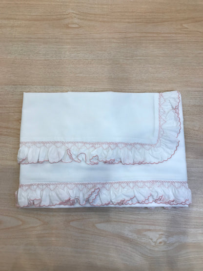 Lenzuolino Colibrì in battista di cotone bianco con rusche ai bordi rosa e lavorazione di punto smock