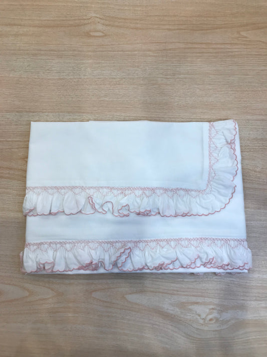 Lenzuolino Colibrì in battista di cotone bianco con rusche ai bordi rosa e lavorazione di punto smock