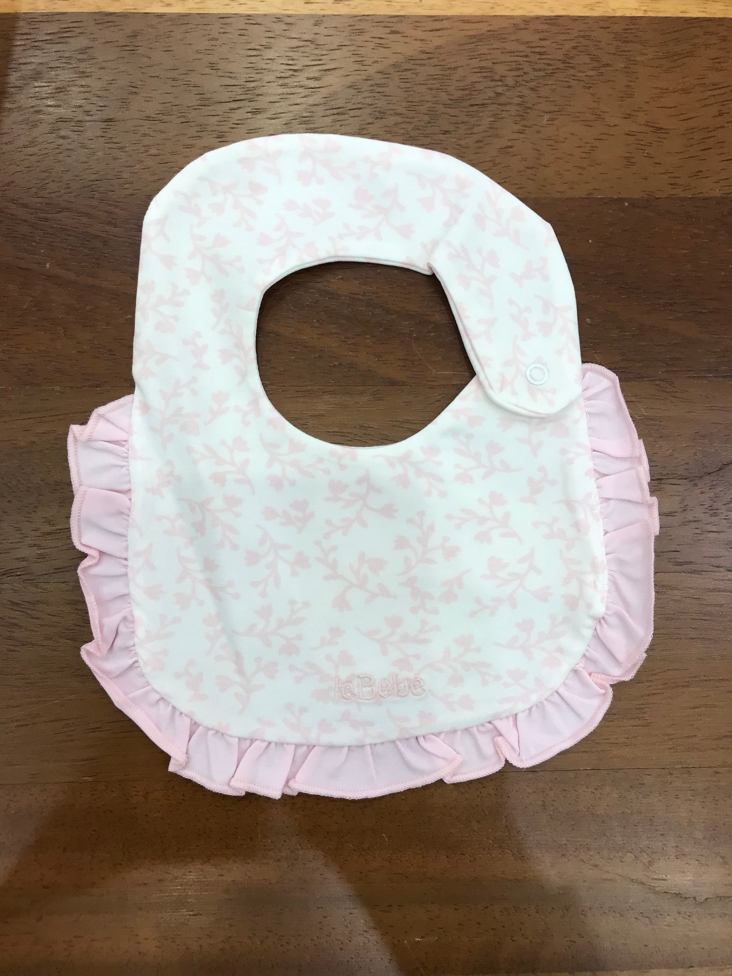Bavetta Le Bebè in cotone con bordo con rusche rosa di base bianco con fiori rosa