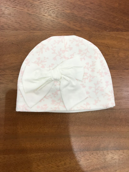 Cappello Le Bebè in cotone bianco con fiori rosa e fiocco centrale bianco sul davanti