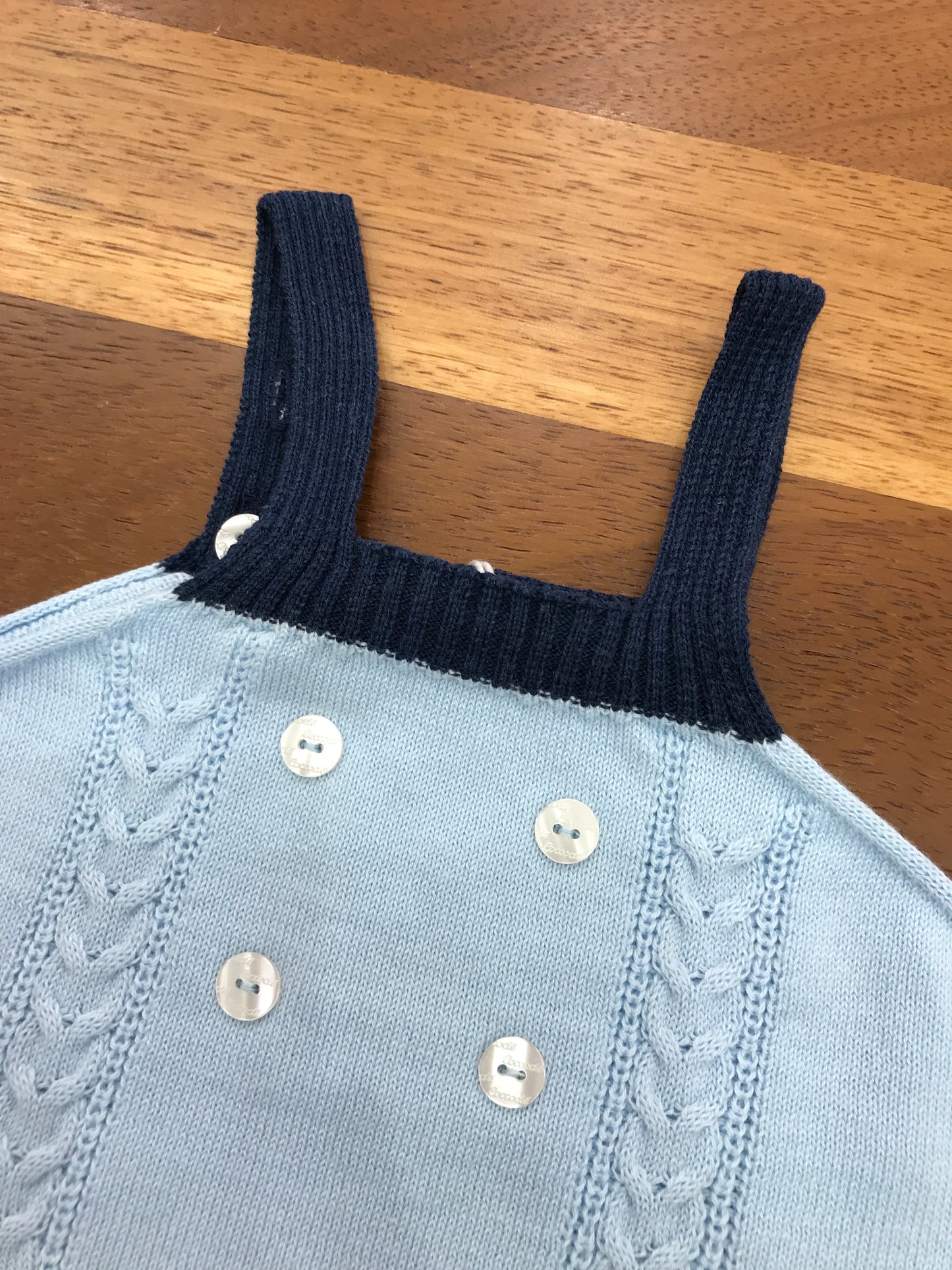 Salopette Coccodè in filo celeste con dettagli blu con bretelle lavorazione di trecce sul davanti con piccoli bottoncini