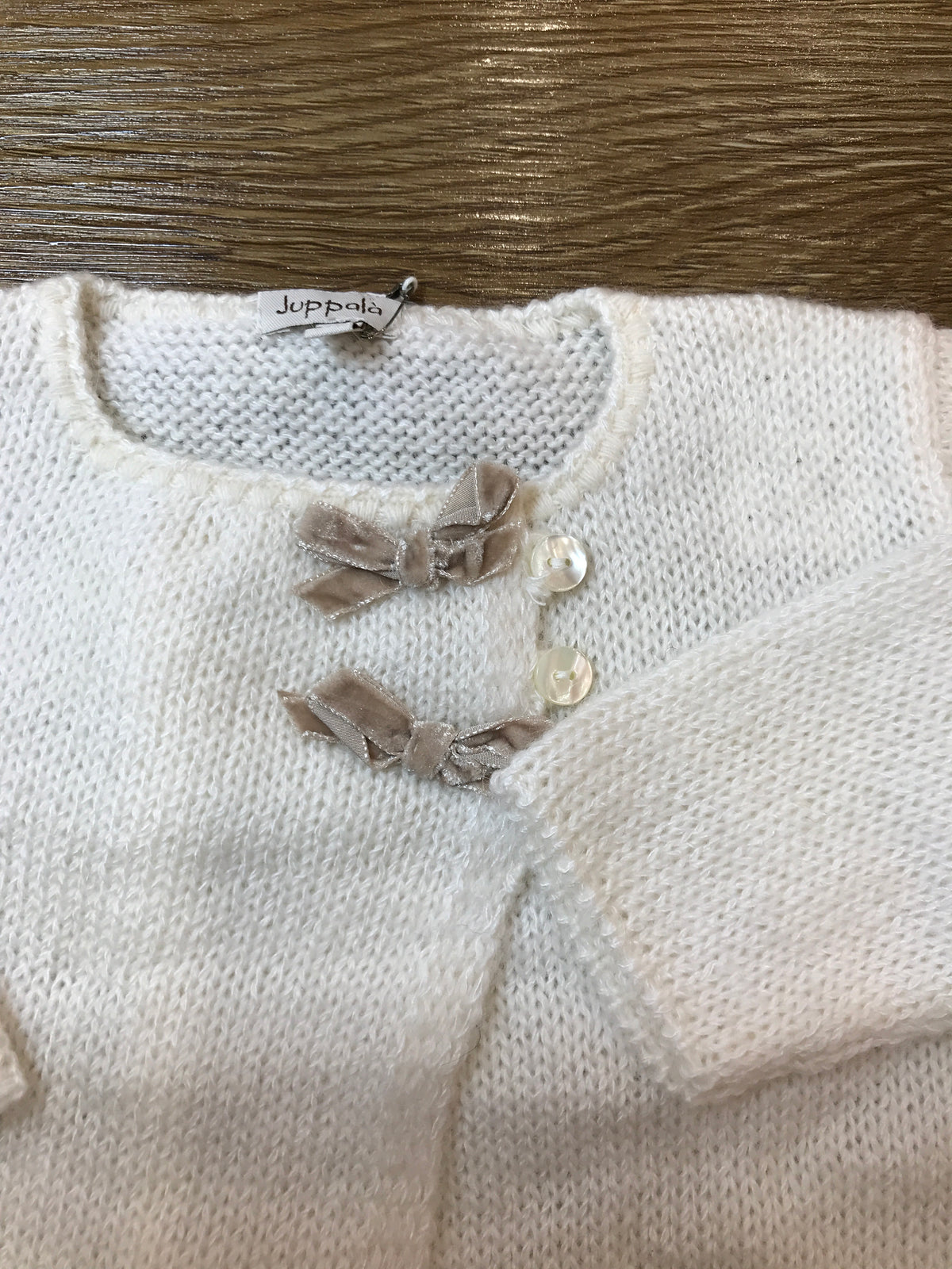 Cardigan Juppolà in lana panna con piccoli fiocchetti in velluto applicati vicino ai bottoncini