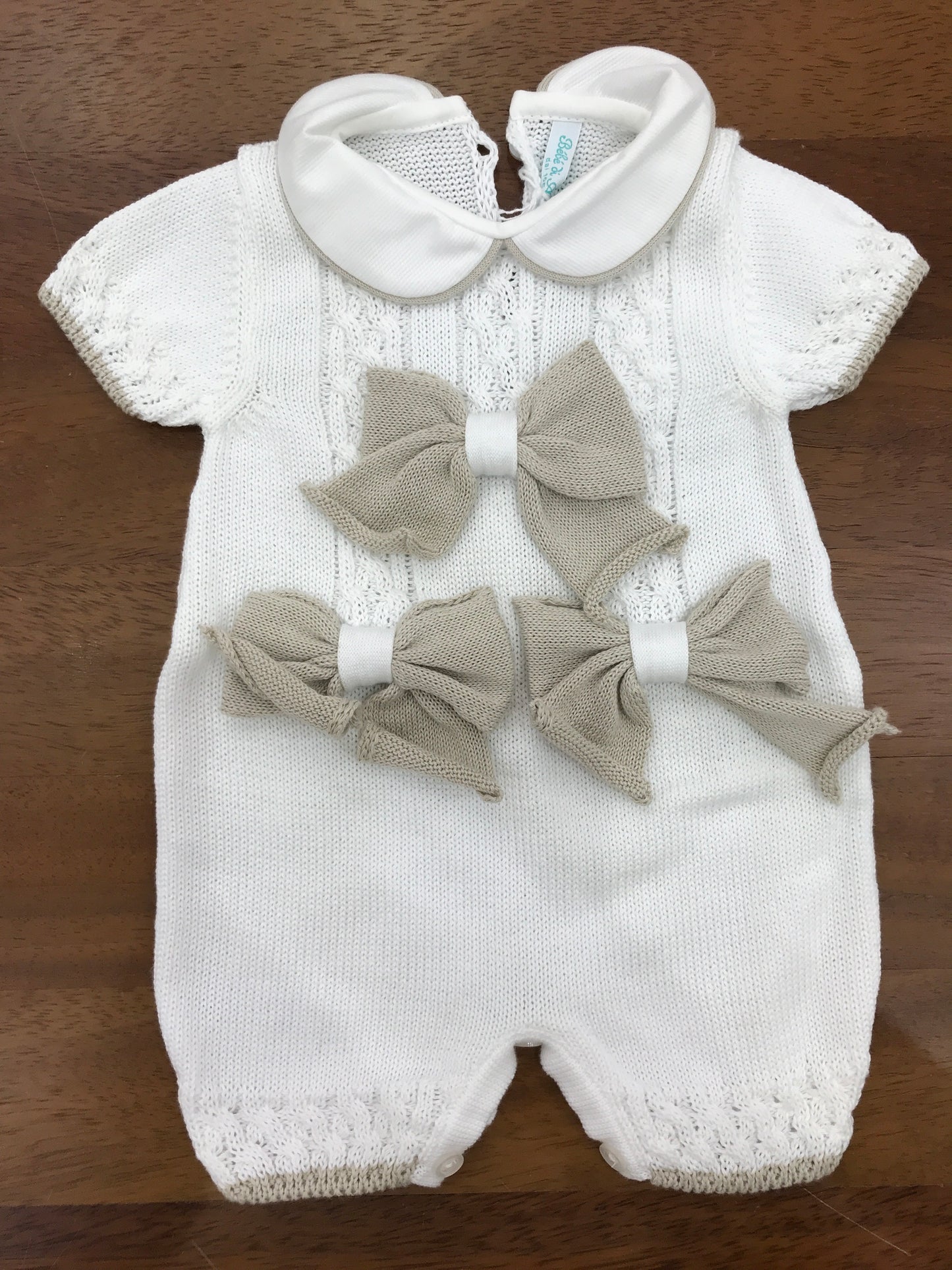 Pagliaccetto Bebè di Almy in filo bianco con fiocchi tortora al centro