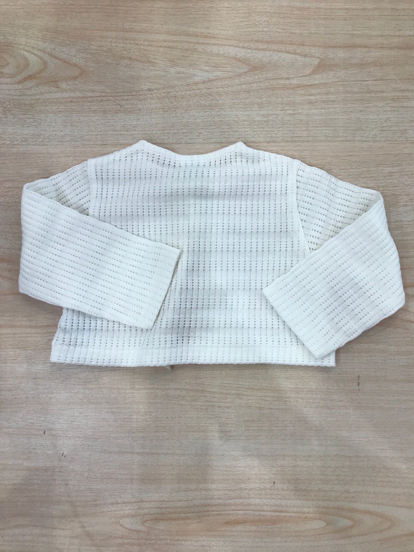 Cardigan La Perla in filo di cotone panna con un bottoncino sul davanti e rusche