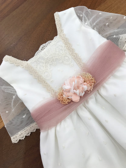 Abito Lilus in cotone mezza manica velata in tulle con pizzo lavorato sul corpetto e sul gonnellone con cintura in tulle rosa con fiori applicati al centro