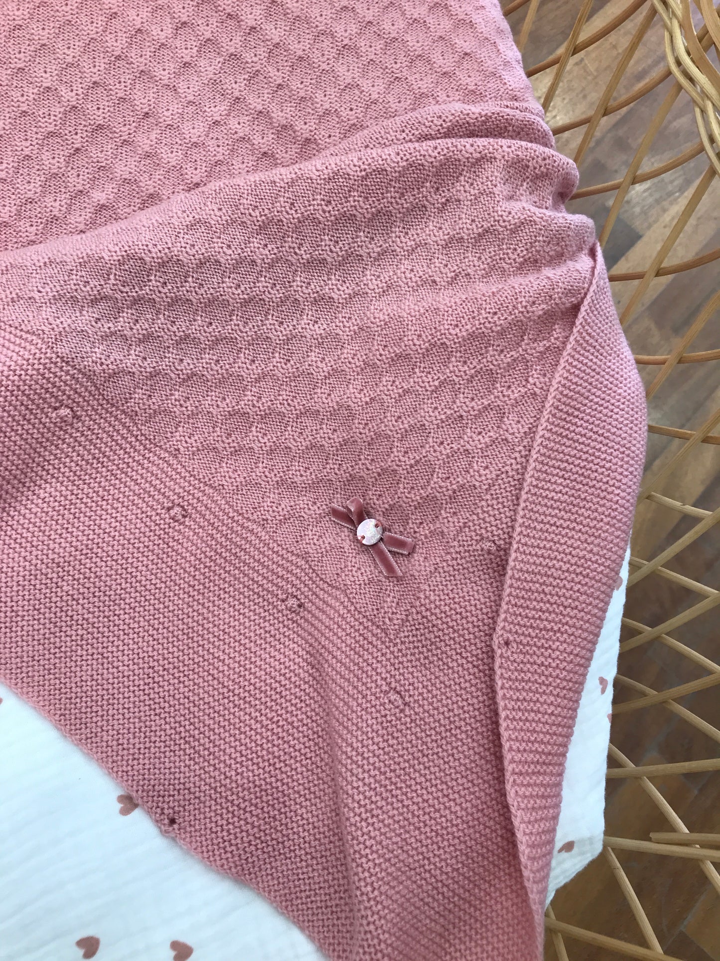 Coperta Paz Rodriguez smerlata dal colore fragola con piccolo fiocchetto in velluto