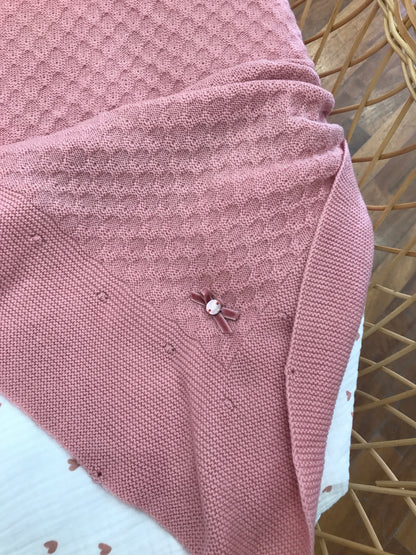 Coperta Paz Rodriguez smerlata dal colore fragola con piccolo fiocchetto in velluto