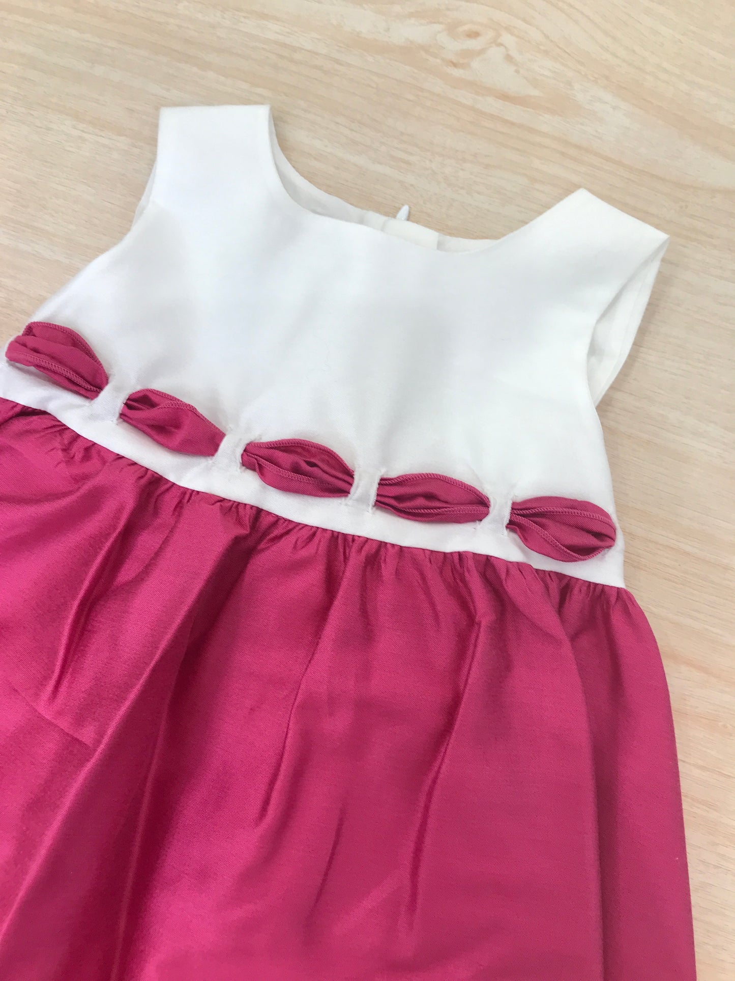 Abito Crochette corpetto bianco smanicato con passanastro fuxia come la gonna ampia e fiocco sul retro