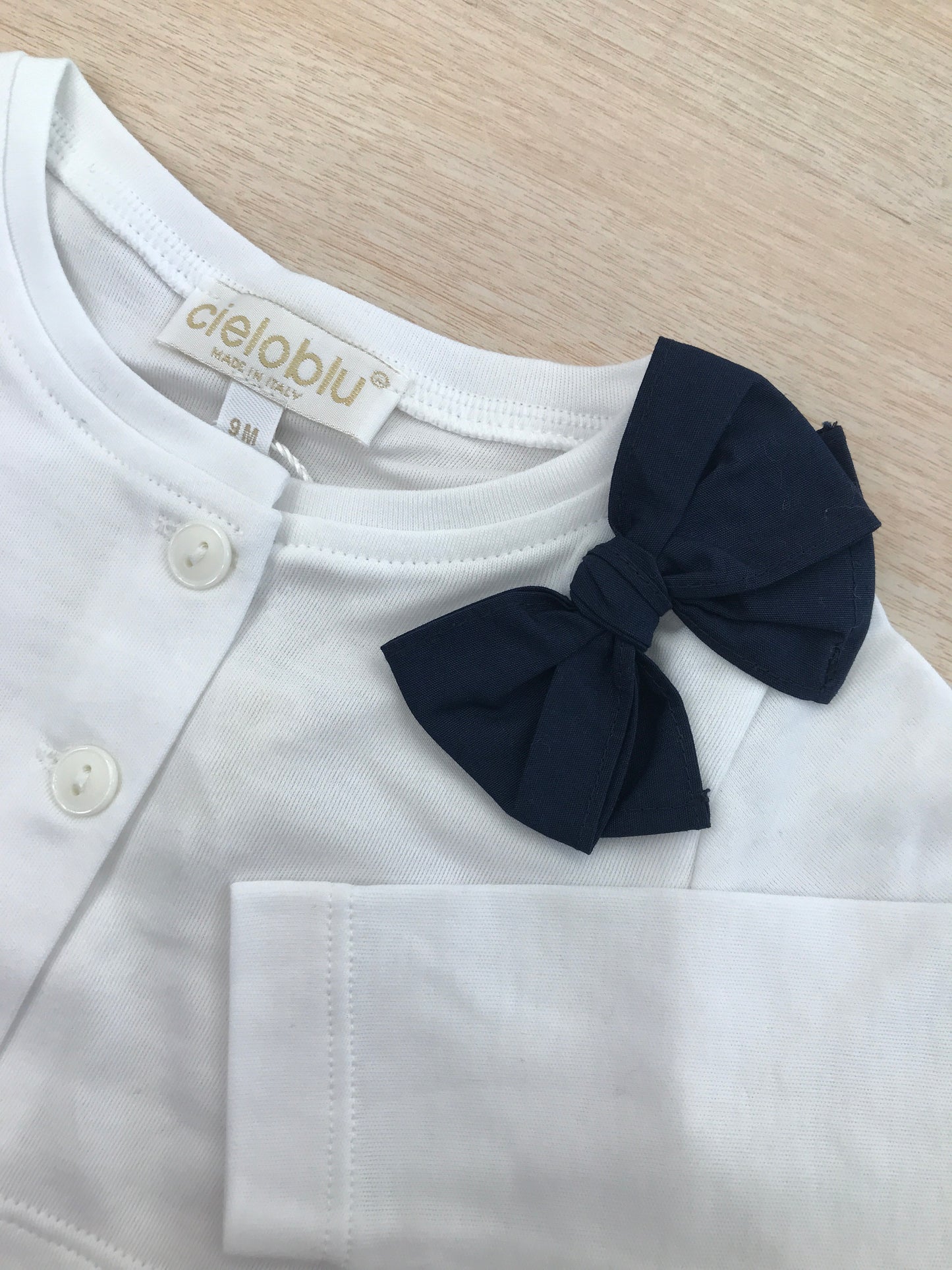 Cardigan Cielo Blu in cotone bianco con bottoncini e fiocco blu laterale