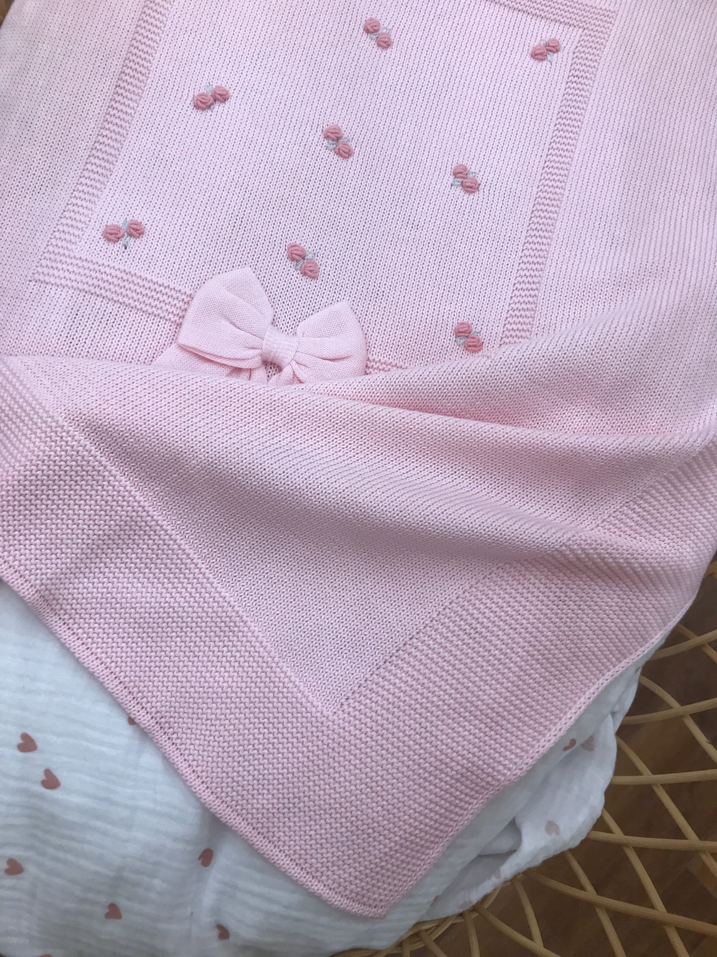 Coperta Baby Lord in filo rosa con rose corallo ricamate a mano con fiocco applicato sul davanti