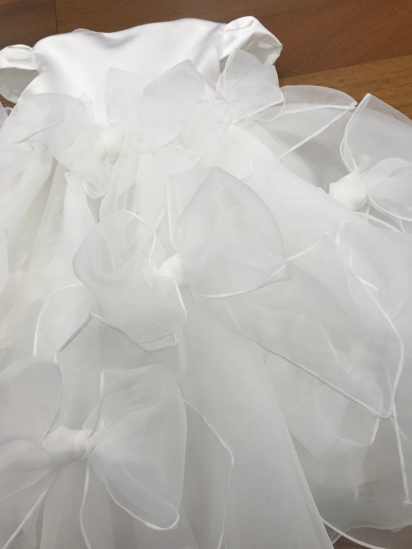 Abito Pure da cerimonia in organza con fiocchi presenti su tutto il gonnellone