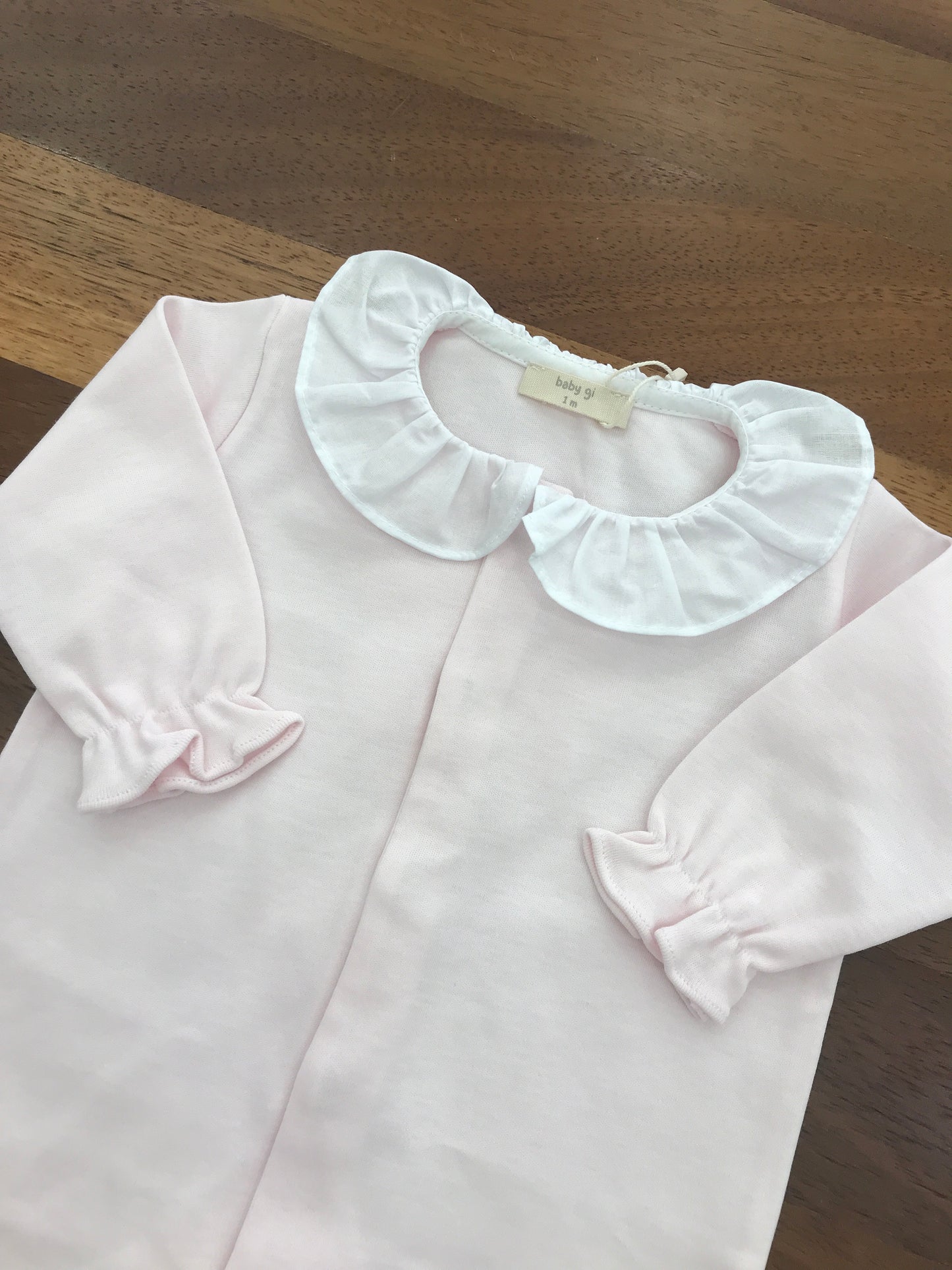 Tutina Baby Gi in cotone con piedini manica lunga con collo con rusche bianca sul retro applicata una farfalla