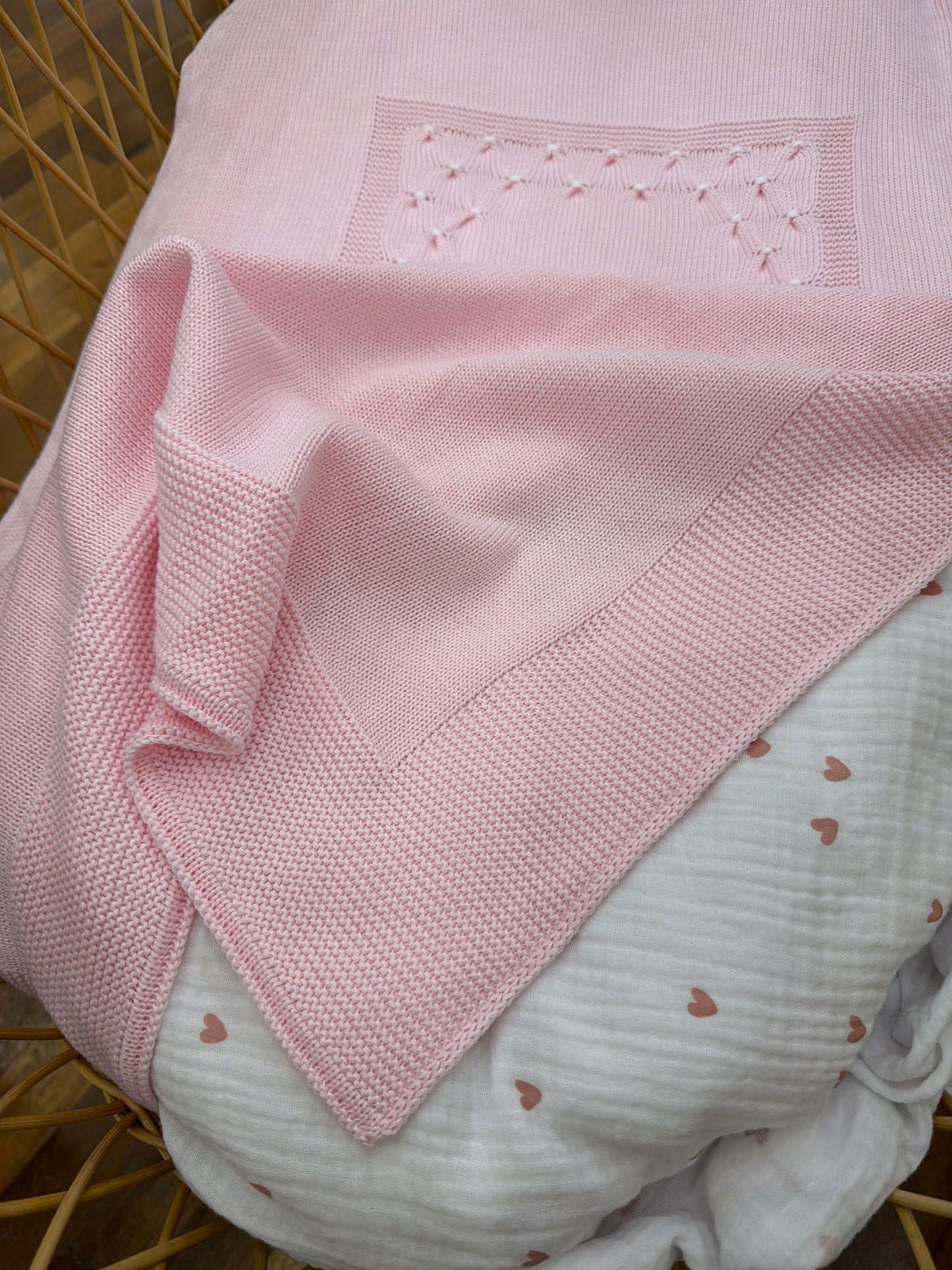 Coperta Baby Lord in filo rosa con lavorazione di punto smock bianco sul davanti