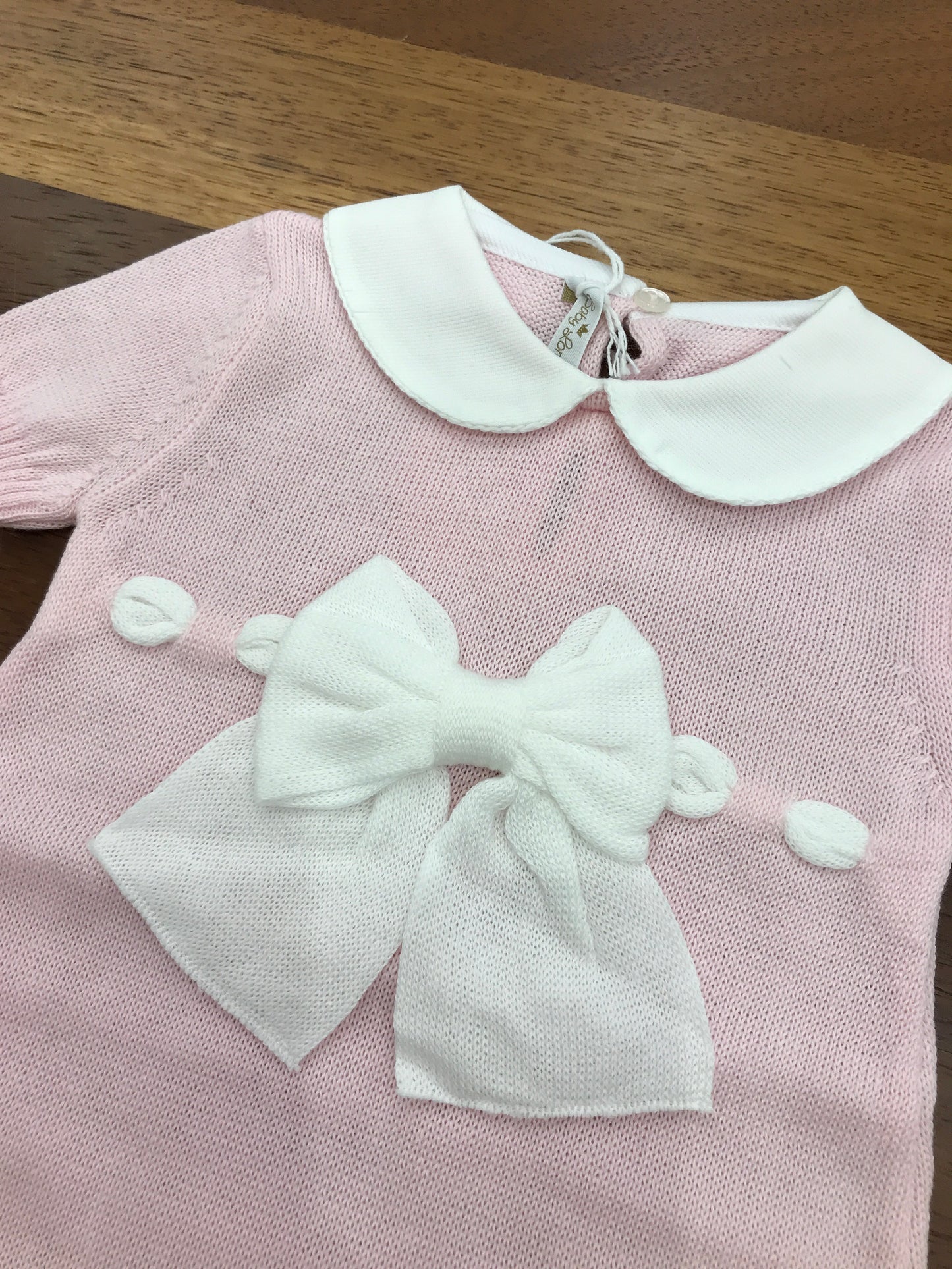 Pagliaccetto Baby Lord in filo mezza manica rosa collo tondo bianco con fiocchetto bianco sul davanti