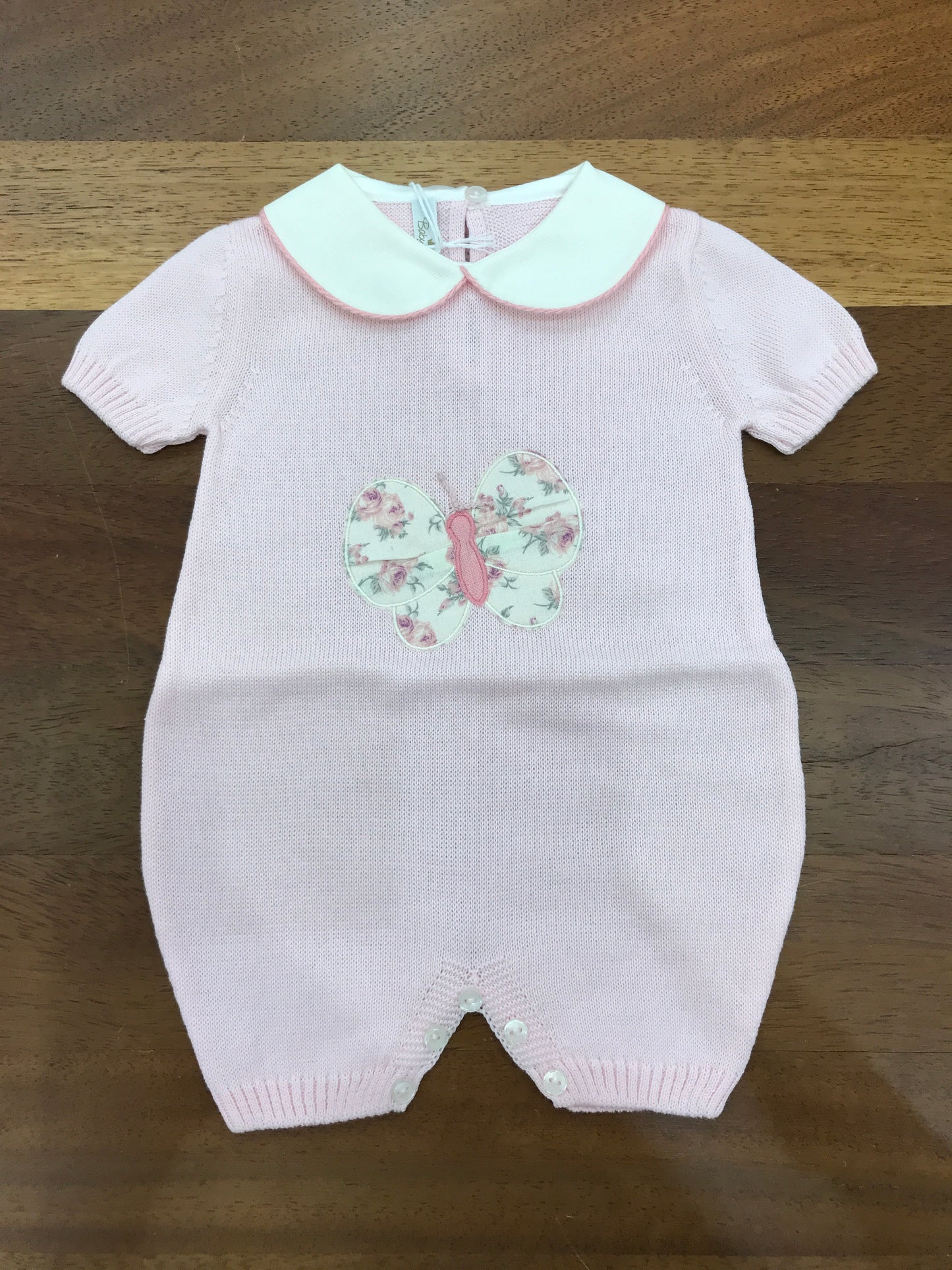 Pagliaccetto Baby Lord in filo rosa con collo tondo mezza manica con farfalla centrale