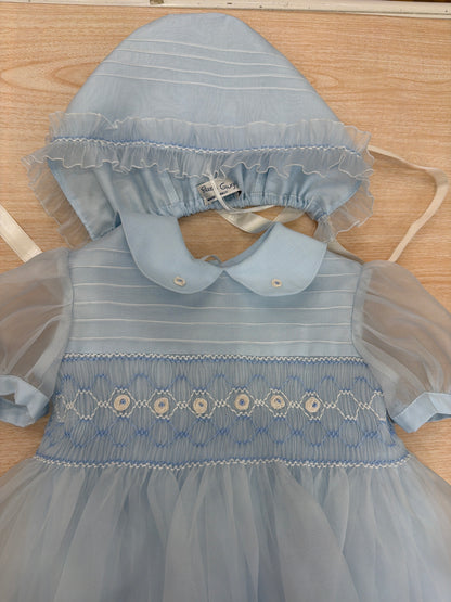 Abito Piccola Giuggiola in organza in seta celeste mezza manica con lavorazione di punto smock e lavorazione di fiori con cuffietta abbinata
